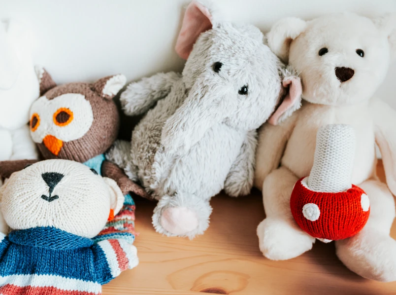 Cute Knitted And Plush Stuffed Animal Toys On Wooden Table