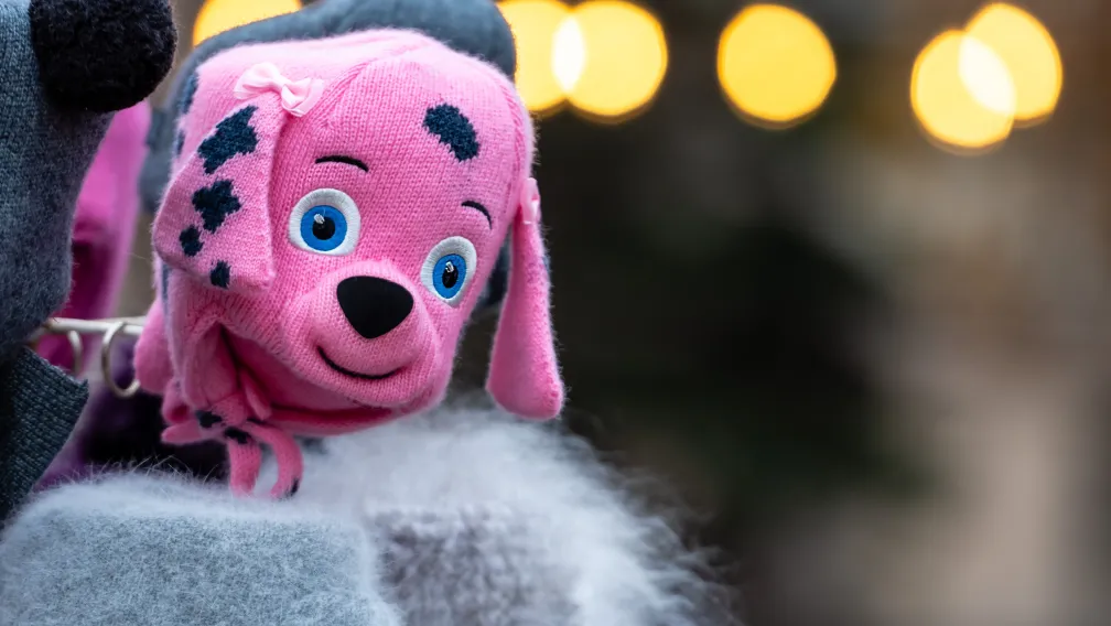 Custom plush dolls in embroidered and printed face versions arranged on a factory inspection table