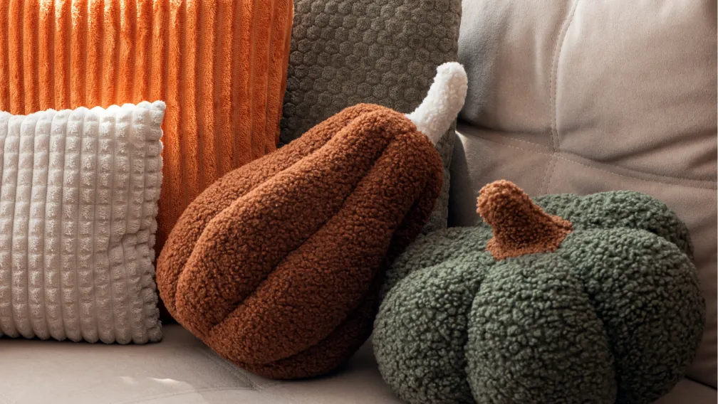 Custom plush pillows in knife-edge, gusseted, and die-cut constructions on a factory inspection table